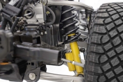 Closeup of the 2021 Bronco independent front suspension featuring two forged aluminum alloy A-arms and available Bilstein long-travel position-sensitive dampers with end-stop control valves.